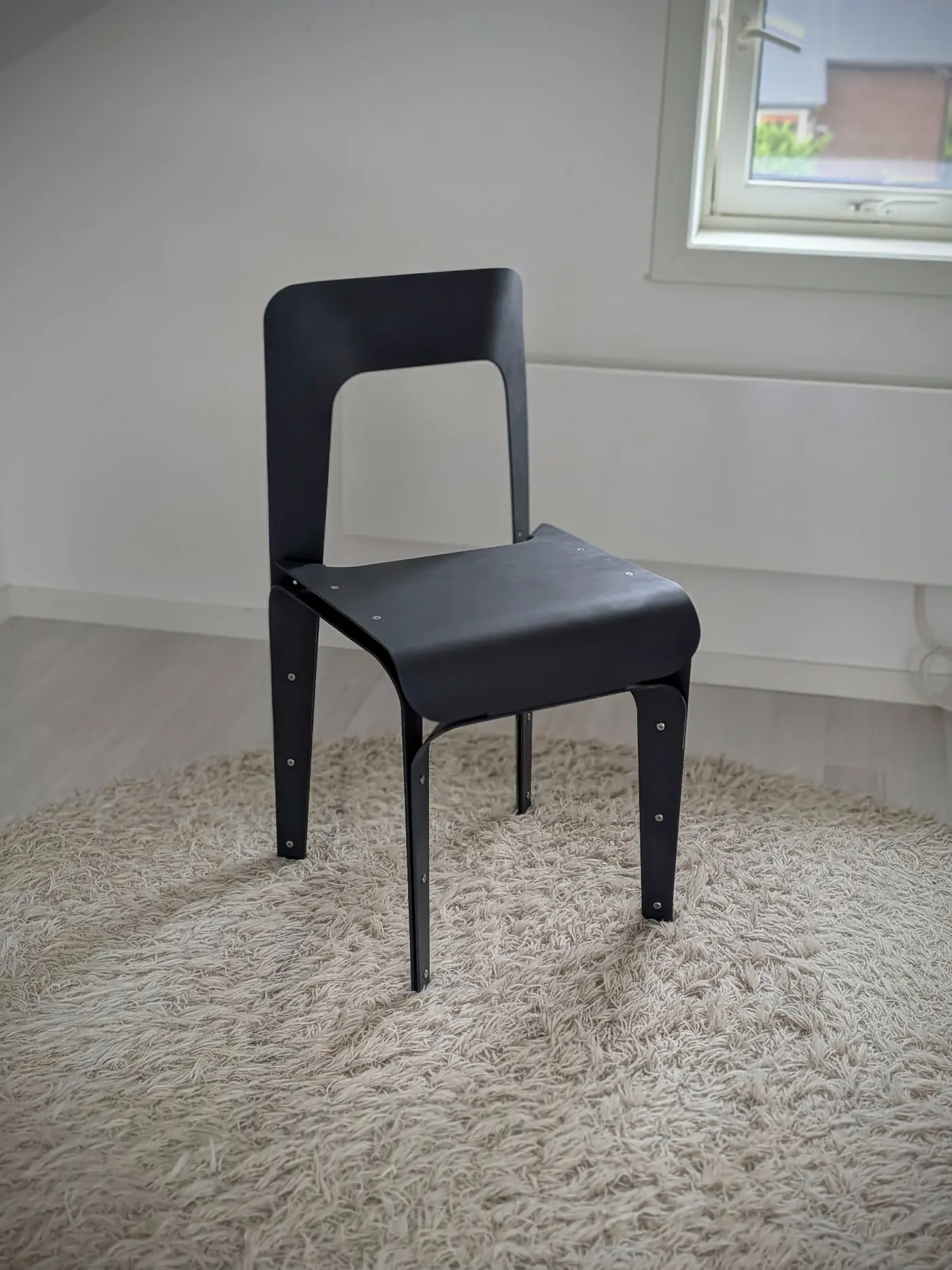 The chair repainted grey, standing in the studio.