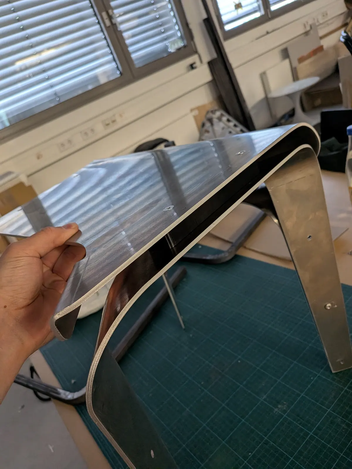 A hand holding a bent 4 mm part with the custom spacer fitted between the layers.