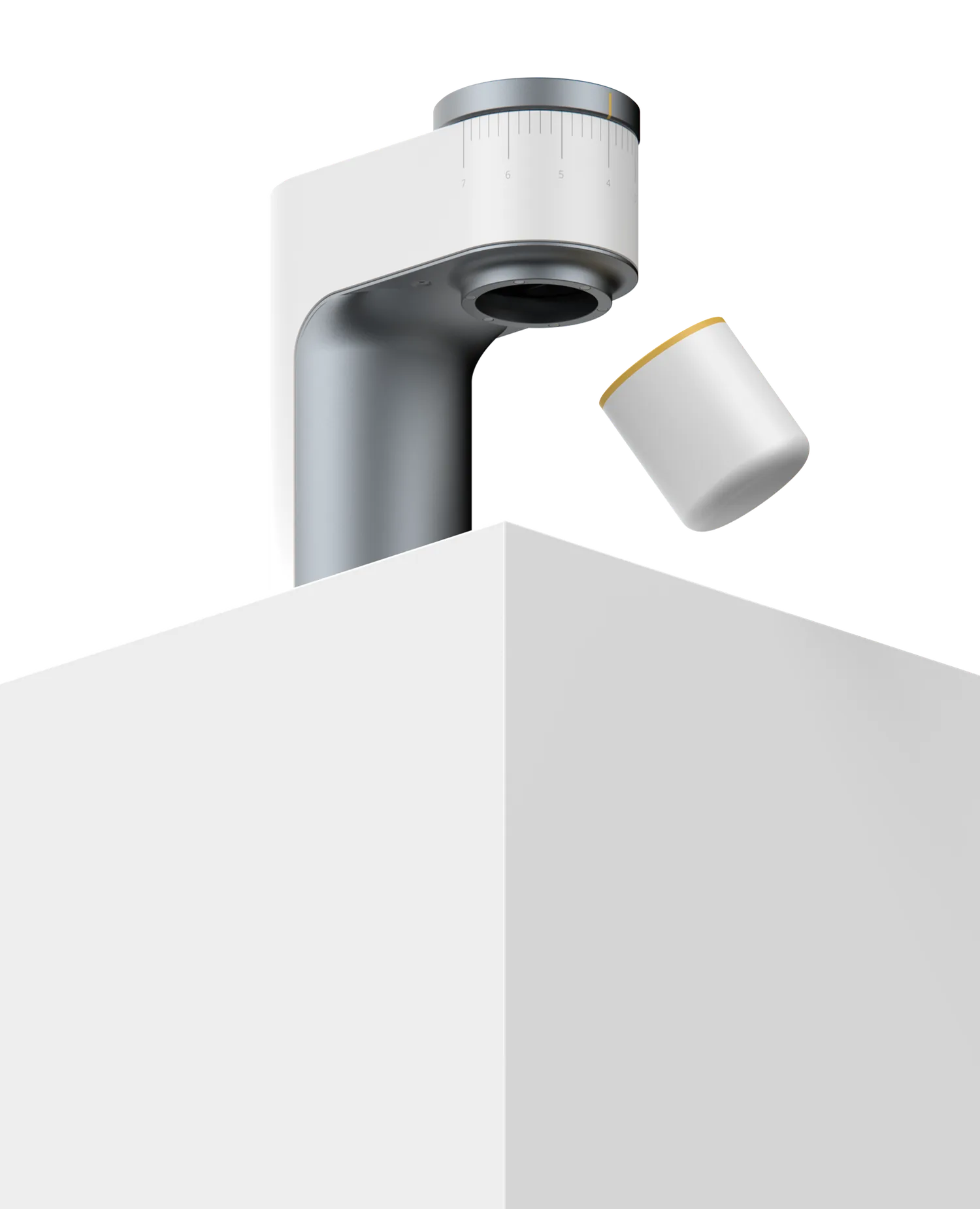 The AERO espresso grinder standing over the edge of a plinth, its dosing cup floating beside it.