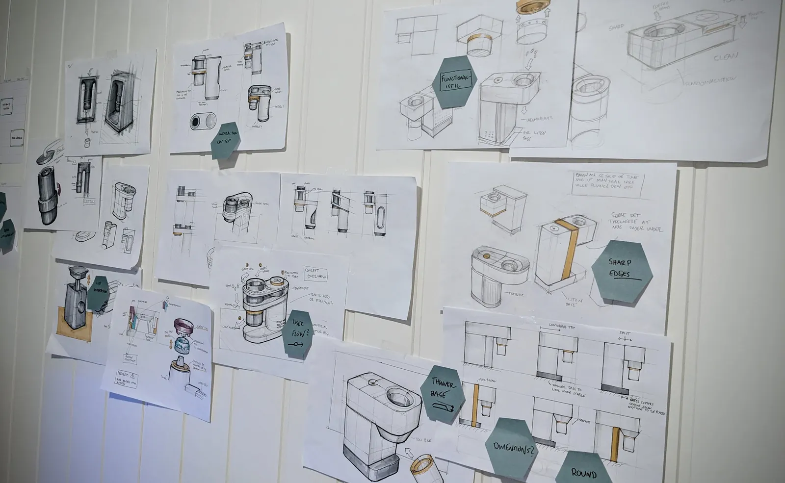 Sketches and drawings pinned across a studio wall.