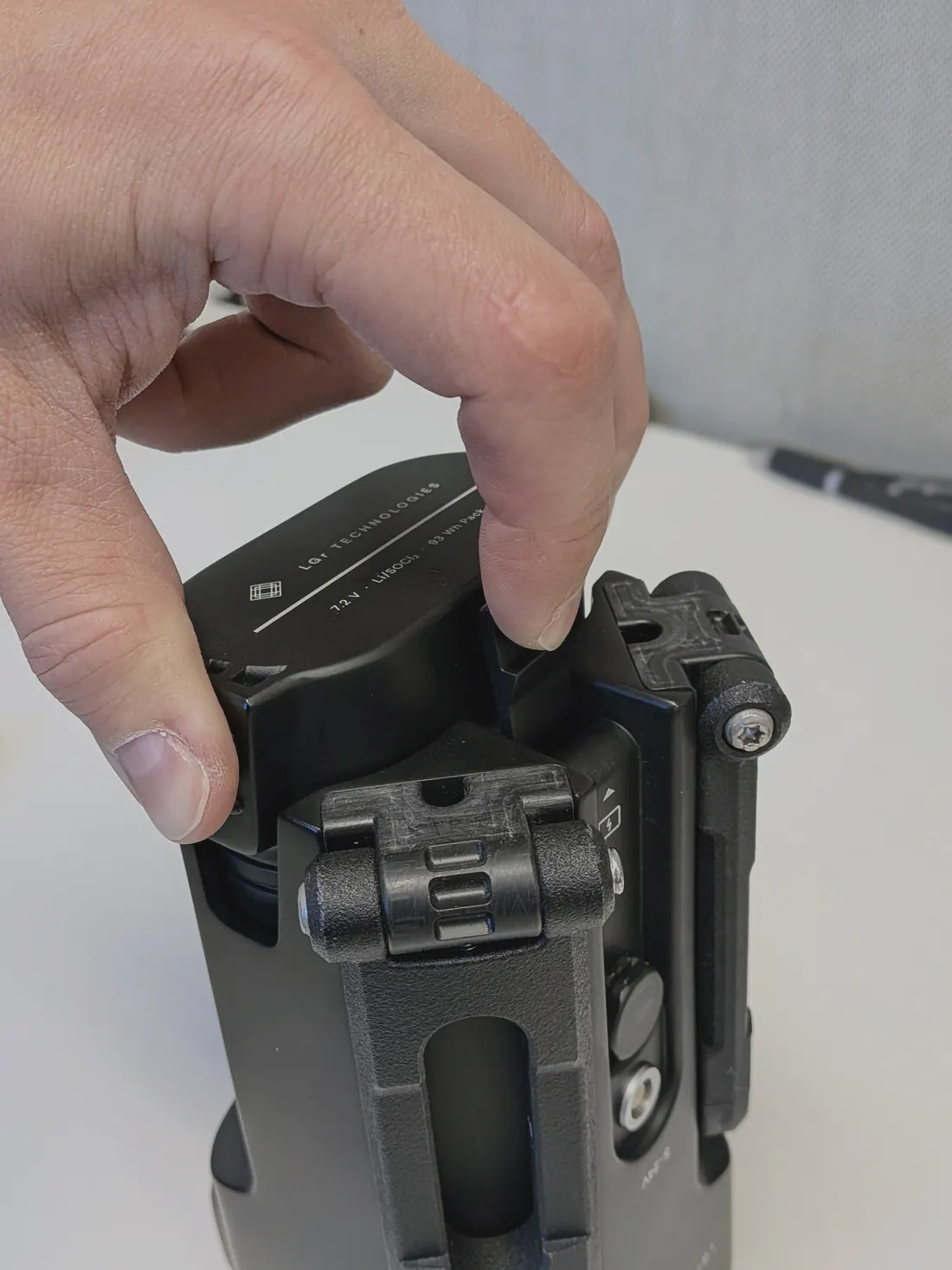 A hand pulling the battery pack out of the body of a printed prototype.