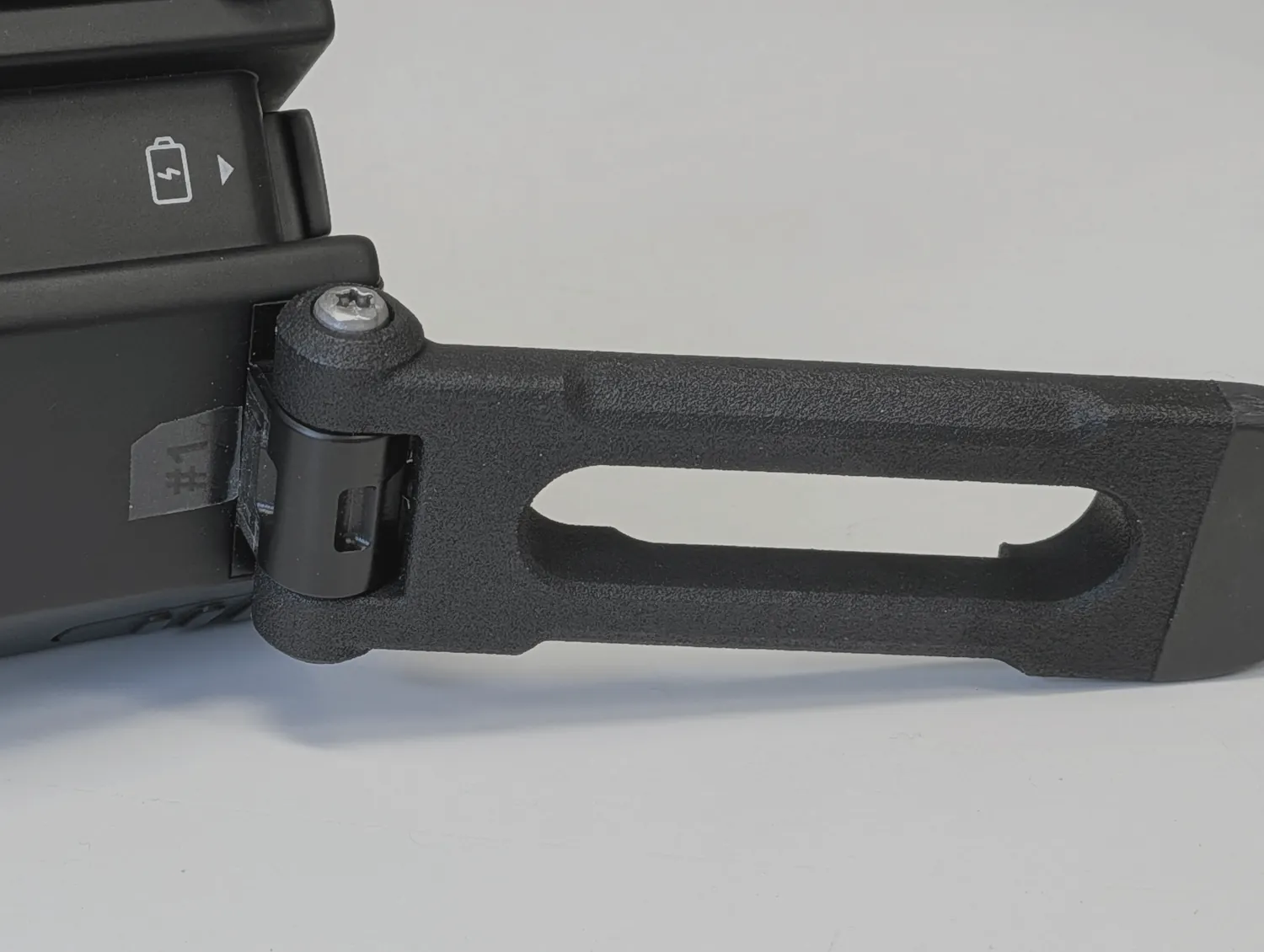 Close-up of the built hinge: the screw, the knuckle and the overmoulded leg swung out.