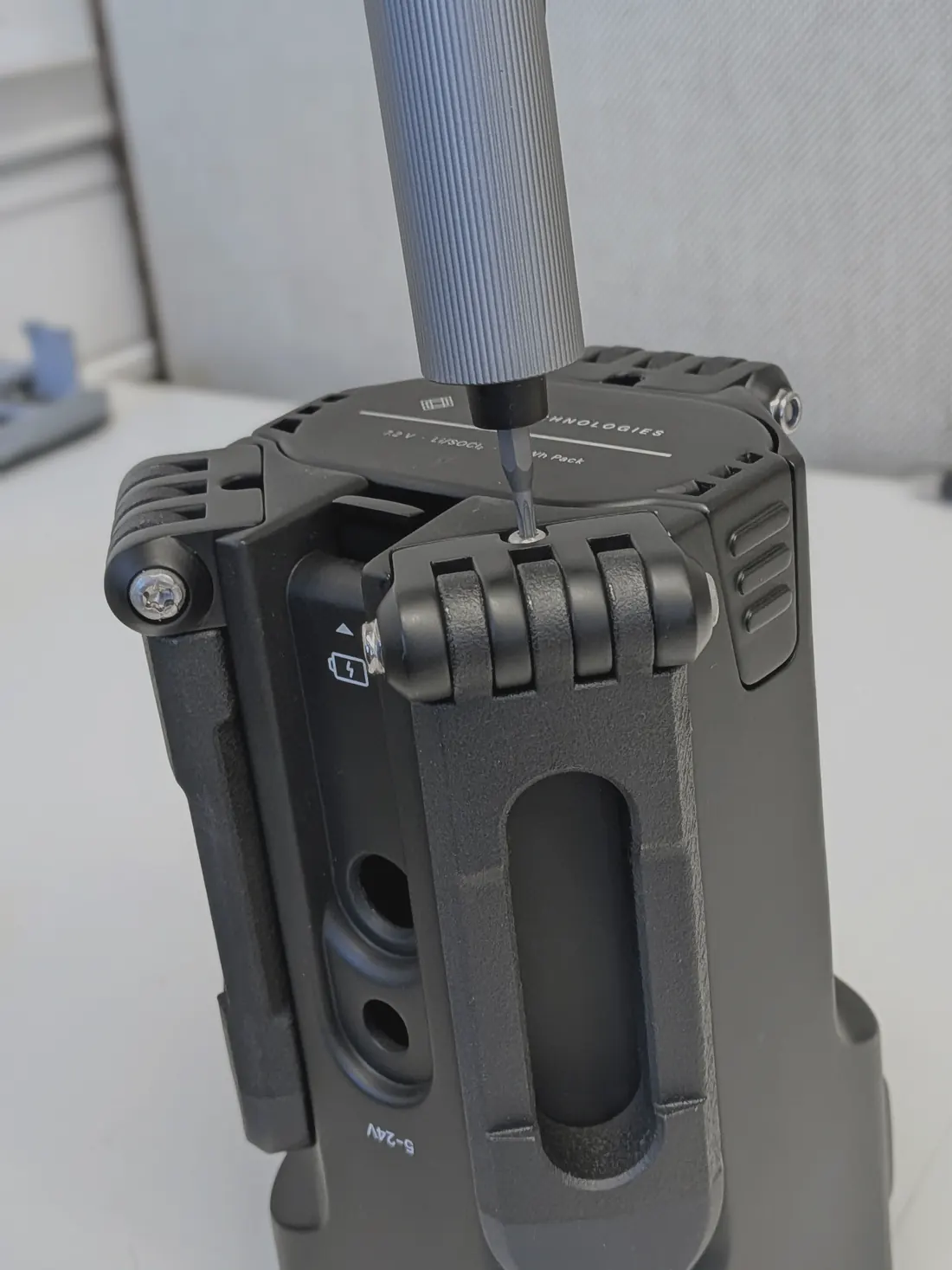 A screwdriver driving the hinge screw on a printed prototype.
