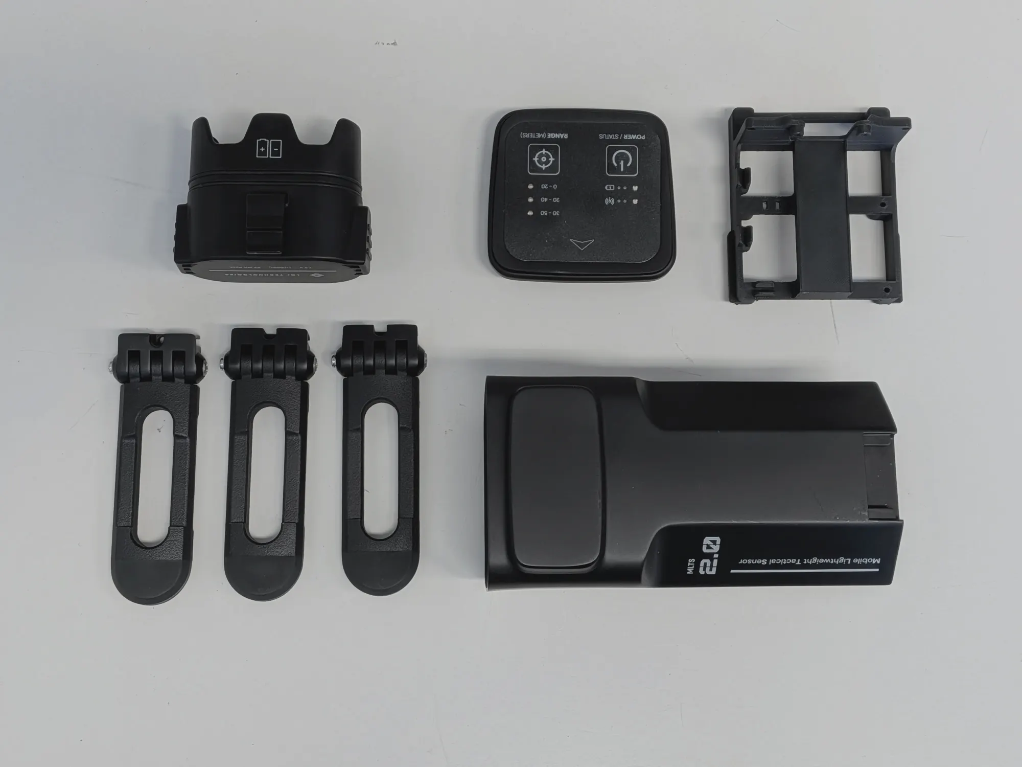Every part of the prototype laid out: battery, top panel, internal chassis, three legs and the main housing.