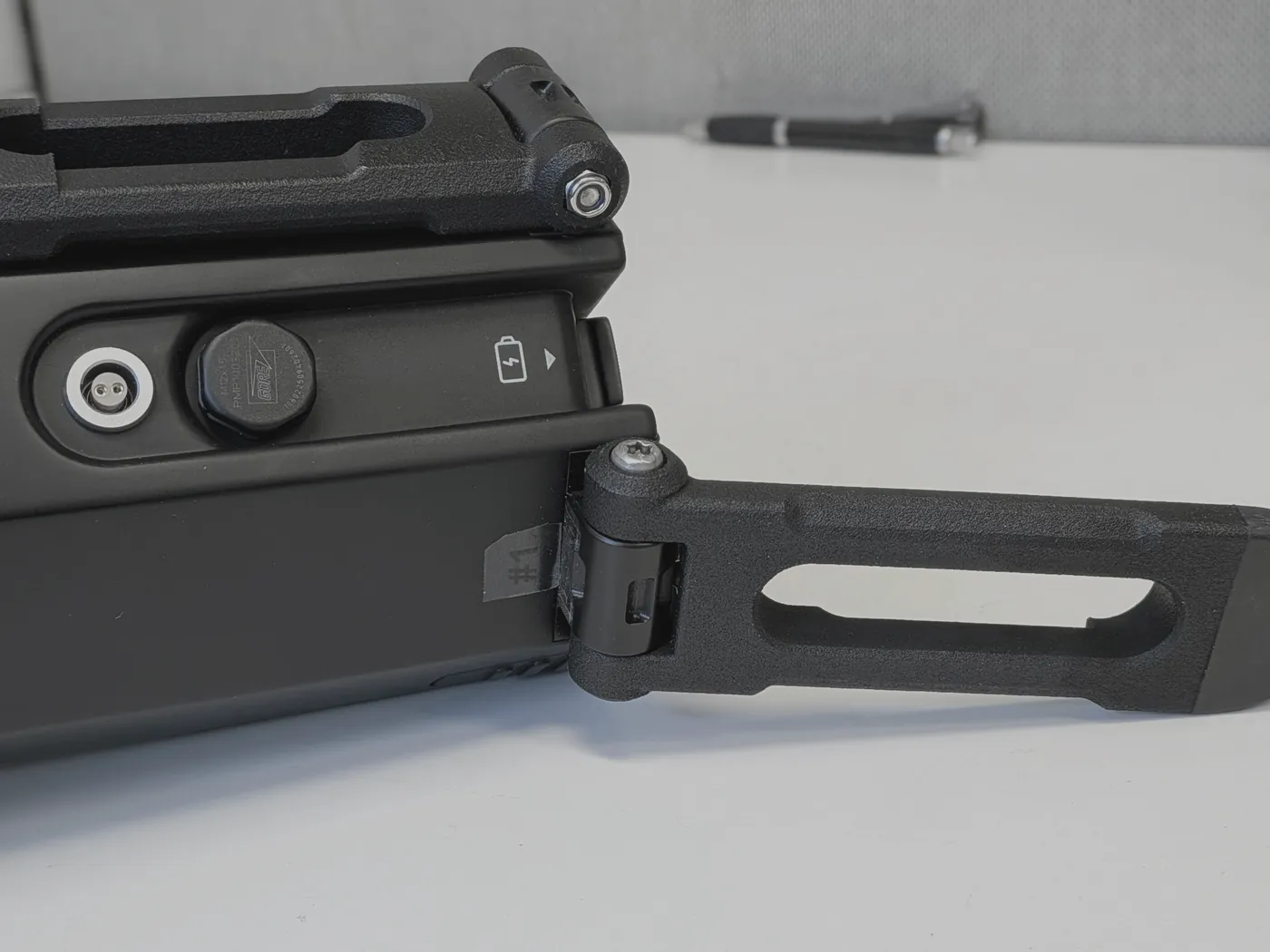 Bench detail: the hinge, the threaded vent plug and the circular connector on the housing.